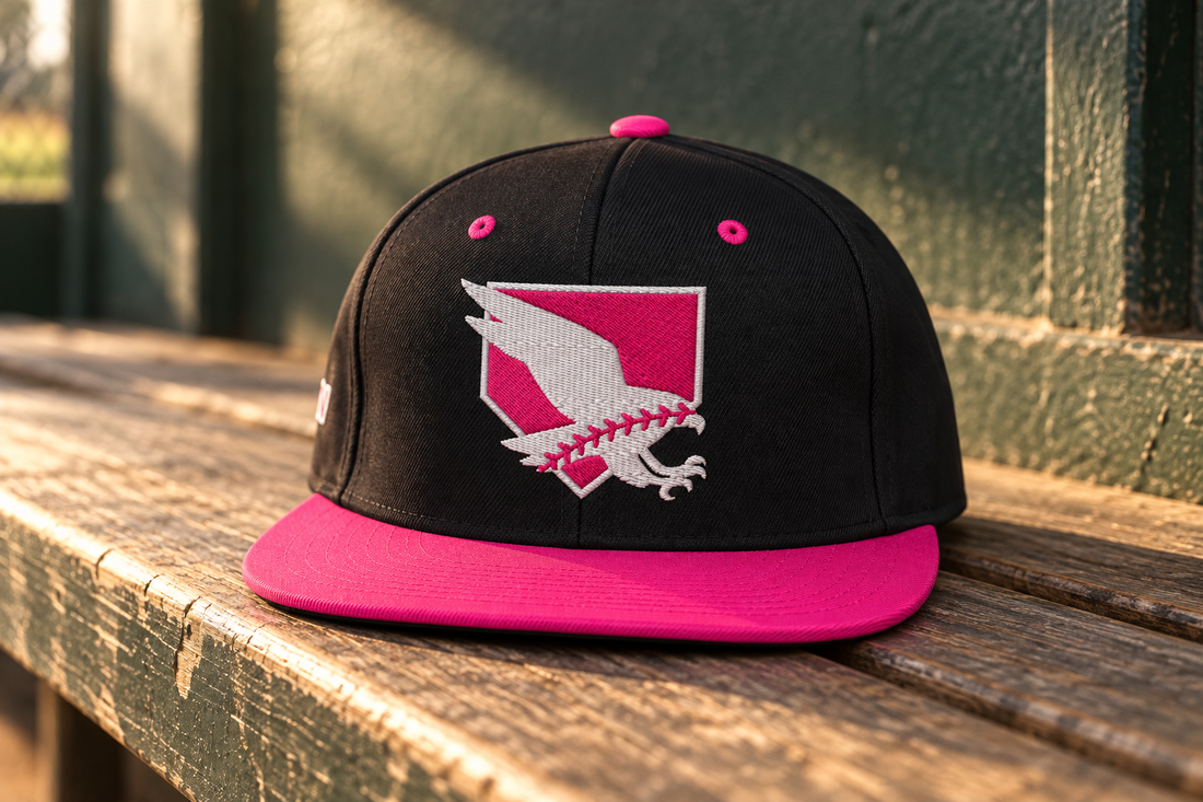 Black and neon-pink Hawk Edge Hat on a wooden dugout bench